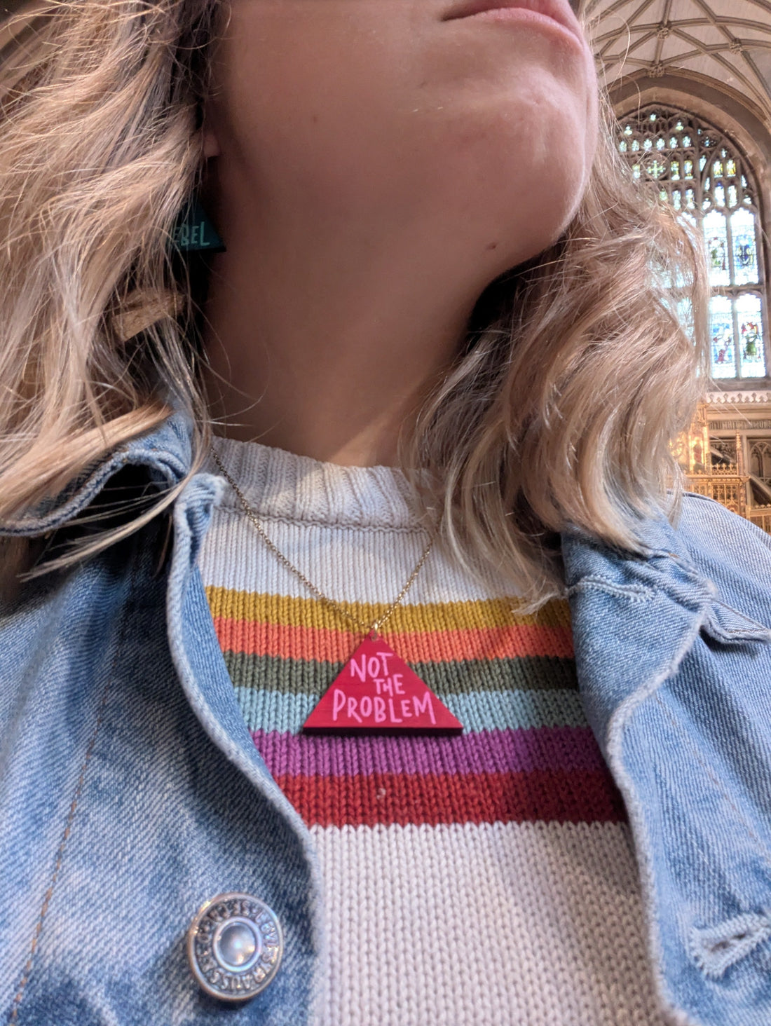 Woman wearing the necklace that says 'not the problem' in red and pink.